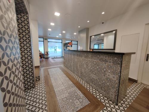 een lobby met een receptiebalie met een tegelwand bij Residencial & Hotel Palazzo in Panama-Stad