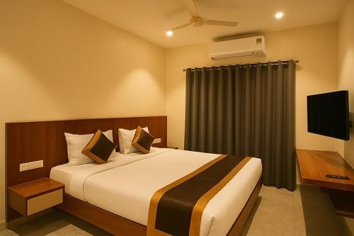 a hotel room with a bed and a television at Hotel Shree Abhishek in Bārāmati