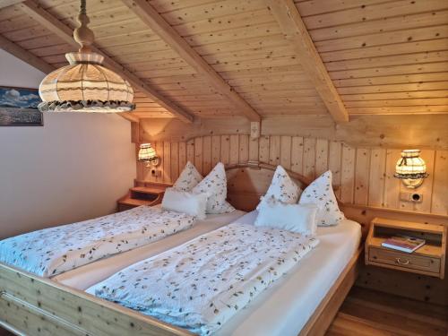 a bedroom with a bed in a room with wooden walls at Ferienhaus Alpenzauber in Krün