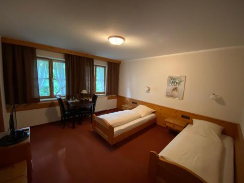 a hotel room with a bed and a dining room at Hotel zur Ulme in Anzing
