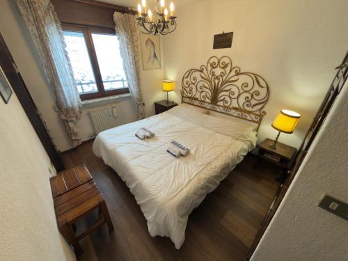 a bedroom with a large bed with two towels on it at Neve 5 Apartment - Clotes Slope Access in Sauze d'Oulx