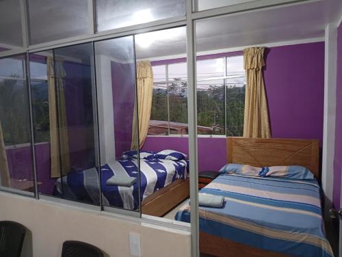 2 bedden in een kamer met spiegelwanden bij Airbn b Estancia ALVARADO 1 in Tingo María