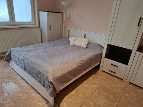 a bedroom with a bed and a dresser with a television at Benett Apartman in Győr