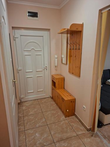 a hallway with a white door and a tiled floor at Benett Apartman in Győr