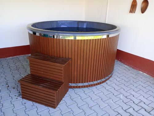 a large wooden tub with a staircase in a room at Akác Apartmanház in Odorheiu Secuiesc