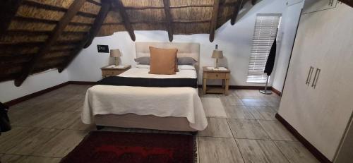 a bedroom with a bed and two tables with lamps at Green Haven Guest Lodge in Pretoria