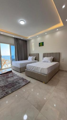two beds in a bedroom with a view of the ocean at White House Boutique Sharm in Sharm El Sheikh