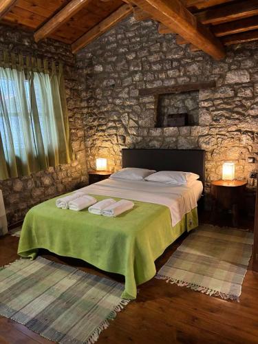 a bedroom with a large bed in a stone wall at Petrina Theohari in Lekhoúrion