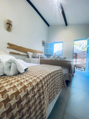 a bedroom with two beds and a window at Vila Refúgio in Aracati