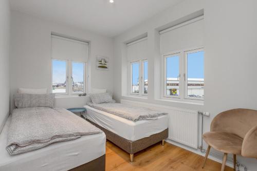 Brúarstræti 1 في سيلفوس: غرفة نوم بها سريران ونافذتان
