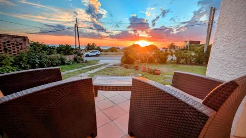 a patio with a table and chairs and a sunset at Lo de las Tías in Balneario Solís