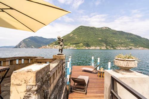 a statue on a dock with a view of the water at Villa Cecilia - pieds dans l'eau in Sulzano