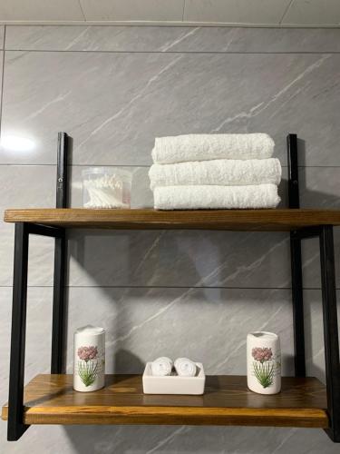 a shelf with towels and two cups and towels at old white house in Kazbegi