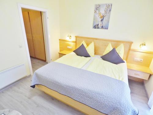 ein Schlafzimmer mit einem großen Bett und blauen Kissen in der Unterkunft Pension Kathi in Sankt Kanzian am Klopeiner See