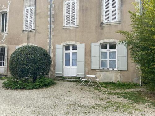 een gebouw met witte deuren en een stoel ervoor bij Le Gîte Du Parc avec parking vieux port et plage au calme in La Rochelle