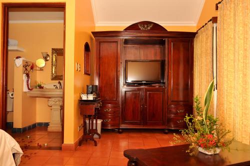 una sala de estar con un gran centro de entretenimiento de madera con TV en Hotel Cuna del Angel, en Uvita