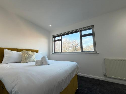 a bedroom with a large white bed with a window at Moor Layover Heathrow - Cozy Crew Stay - 10 min to Airport in Harmondsworth