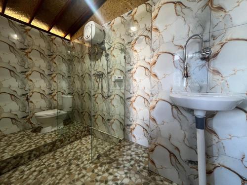 a bathroom with a sink and a toilet at Tutwin Guesthouse in Krambitan