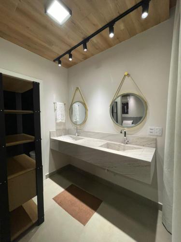 a bathroom with two sinks and a large mirror at Condômino Max life in Pipa