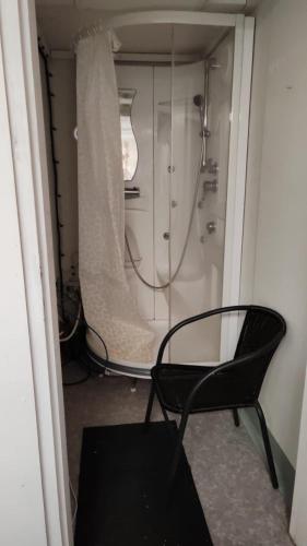 a bathroom with a shower and two chairs in a room at Lemmenjoen Lumo - Nature Experience & Accommodation in Lemmenjoki