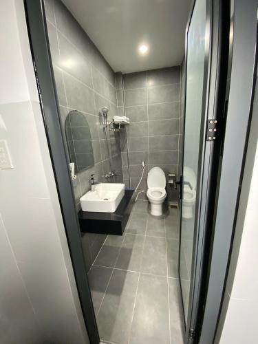 a bathroom with a toilet and a sink at Nhà Nghỉ Phi Yến in Phụng Hiệp