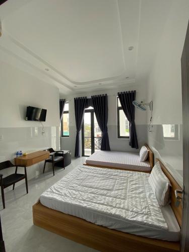a bedroom with a large bed and a desk at Nhà Nghỉ Phi Yến in Phụng Hiệp