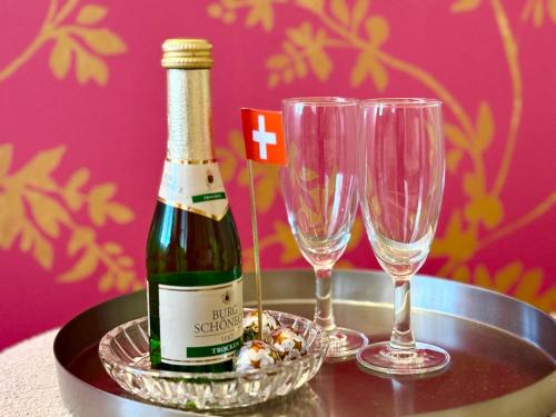 una bottiglia di vino e due bicchieri su un tavolo di Beautiful studio in a villa from 18th century a Thun