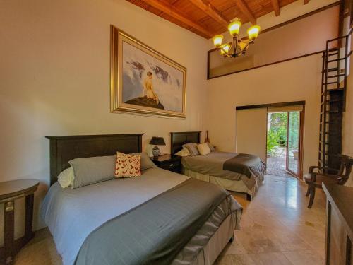 a bedroom with two beds and a chandelier at Villas Valle in Valle de Bravo