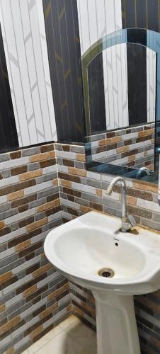 a bathroom with a white sink and a mirror at Shanti palace and restaurant Ayodhya 1500 mtr Sri Ram Mandir ,near ayodhya dham railway station in Ayodhya