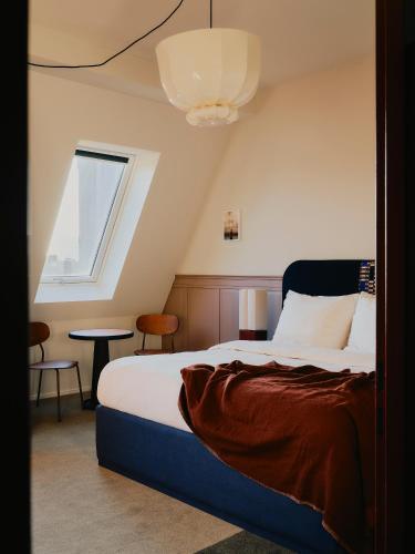 a bedroom with a bed and a window and a table at The Dean Berlin in Berlin