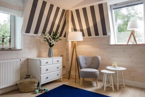 a childs room with striped walls and a table and chair at Willa Błękit Hotel by Dorota Szelągowska in Mielno