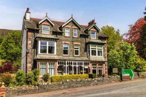 una grande casa in mattoni sul lato di una strada di Woodside B & B a Keswick