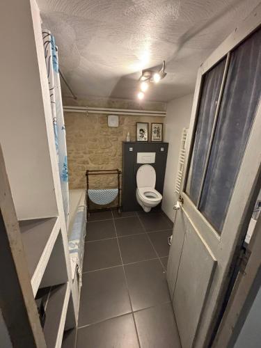 a small bathroom with a toilet and a door at Chez Zabou in Carpentras