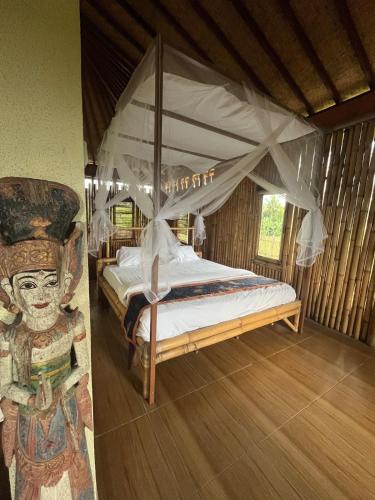a bedroom with a bed with a canopy at Cacao Bamboo House in Krambitan