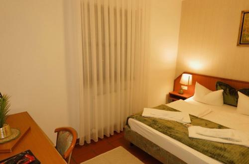ein Schlafzimmer mit einem Bett, einem Tisch und einem Fenster in der Unterkunft Fünf A in Fürth