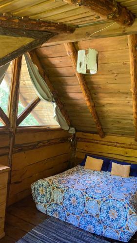 a bedroom with a bed in a wooden attic at Cabaña Mirador del Valle in Lago Puelo
