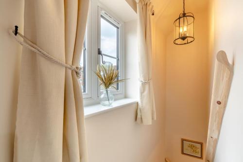 a bathroom with a window and a vase of flowers on a window sill at 2 Bed in Bewdley oc-n31968 in Bewdley