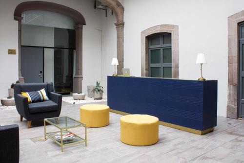 a lobby with a blue counter and yellow stools at Markee Hotel Boutique in Querétaro