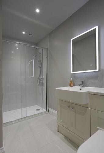 a bathroom with a shower and a sink and a mirror at 3 Bed in Barsham oc-bbarn in Beccles