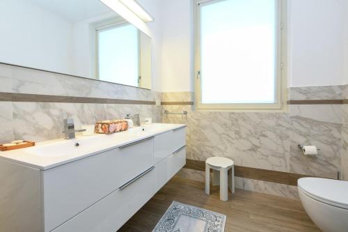 a bathroom with a white sink and a toilet at Villa Mirador in Padenghe sul Garda