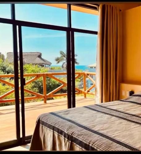 a bedroom with a bed and a view of the ocean at Luxury Ocean View Villa in Brisas de Zicatela