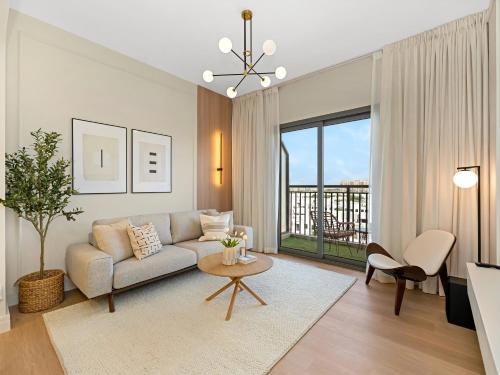 a living room with a couch and a table at The Town Square Suite Luxury 2BR Near Qudra Lake in Dubai