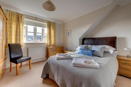 a bedroom with a large bed and a chair at 2 Bed in Southwold oc-scl in Reydon