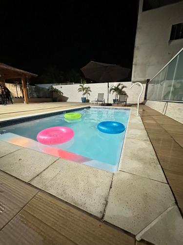 three frisbees in a swimming pool at night at House in Iriri in Anchieta