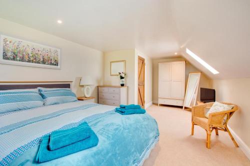 a large bedroom with a blue bed and a chair at 3 Bed in Thursford oc-2370 in Thursford