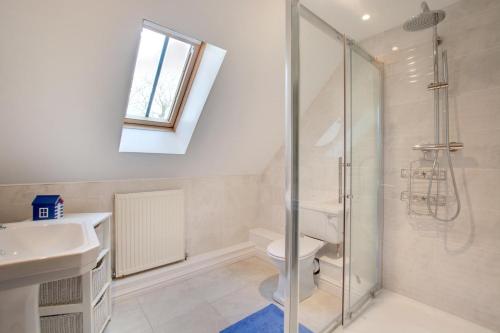 a bathroom with a shower and a toilet and a sink at 3 Bed in Thursford oc-2370 in Thursford