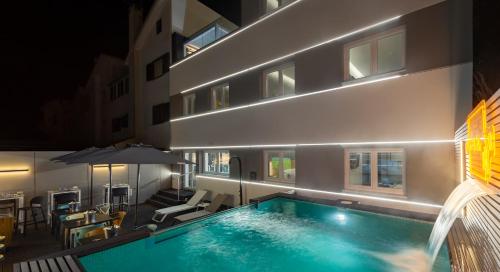 a swimming pool in front of a building at night at Porta 30 in Oeiras