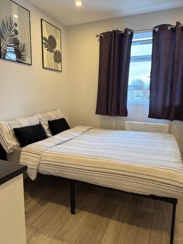 a large bed in a room with a window at Brigstock 4 in Thornton Heath
