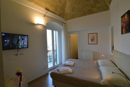 a bedroom with a bed and a large window at L'Affaccio Dell'Abate in Matera