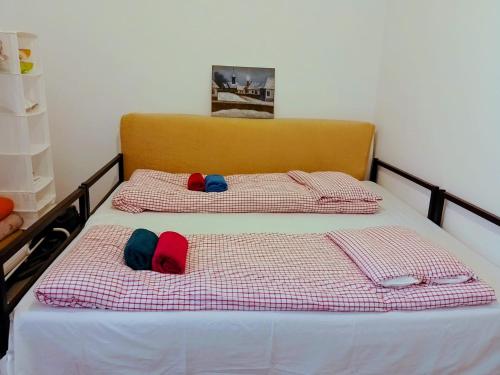 two beds with hats on them in a bedroom at Happy Place Apartment in Lupeni